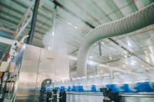 motion blurred fast moving water bottles at Mineral water Factory production line at finishing line in a row moving queuing for labelling packing